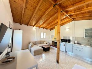 a large living room with a couch and a kitchen at ATHENS AIRPORT - SEASIDE STUDIO - Artemida in Artemida