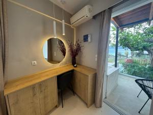 a room with a vanity with a mirror and a window at Eleftherias Suites - Near Beach Apartments in Marathi