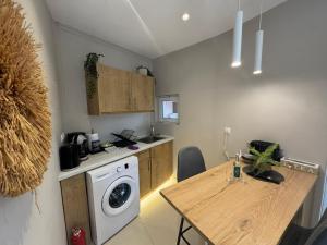 a kitchen with a washing machine and a wooden table at Eleftherias Suites - Near Beach Apartments in Marathi