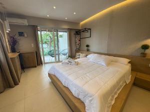 a large bedroom with a large bed with white sheets at Eleftherias Suites - Near Beach Apartments in Marathi