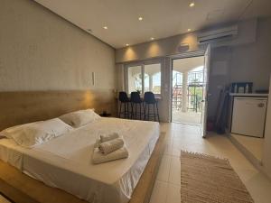 a bedroom with a large bed with white sheets at Eleftherias Suites - Near Beach Apartments in Marathi