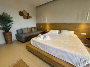 a bedroom with a large bed and a couch at Eleftherias Suites - Near Beach Apartments in Marathi