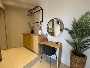 a mirror and a desk in a room with a plant at Eleftherias Suites - Near Beach Apartments in Marathi