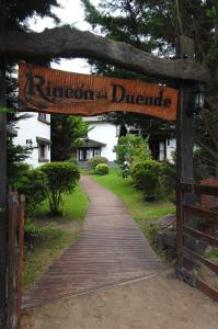 Rincón del Duende Resort y Spa de Mar في مار دي لاس بامباس: الممر الخشبي مع وجود لافته تنص على هذيان الطلاق