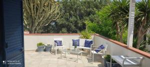 patio con sedie e tavolo con cuscini blu di Villa Malsine a Marzamemi