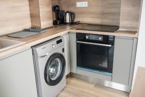 a kitchen with a washing machine and a sink at ТОП Апартаменти в Панорама Парк in Plovdiv
