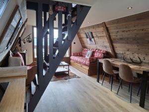 a living room with a staircase and a dining room at Chalet Cosy Cabane avec vue lac in Les Angles