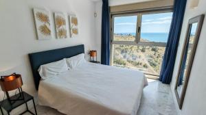 sypialnia z łóżkiem i dużym oknem w obiekcie Benidorm High rise apartments - Sea Views - Torre Lugano w mieście Benidorm