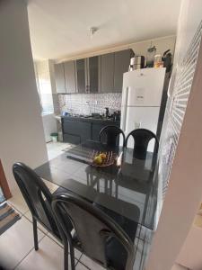 a kitchen with a table and chairs and a refrigerator at Goiás Brasília Confort in Valparaíso de Goiás