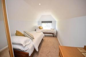 a room with two beds and a mirror at Waters Edge Cottage - Wroxham in Wroxham