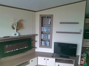 a living room with a flat screen tv and a entertainment center at 'Falcons Rest' in Borth