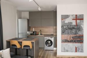 a kitchen with a table and a washing machine at ТОП Апартаменти в Панорама Парк in Plovdiv