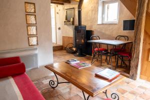 un soggiorno con un tavolo e una stufa a legna di Moulin de la Diversiere a Savigné-sous-le-Lude