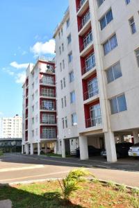 two tall apartment buildings with cars parked in front of them at Serene Getaway Studio Along Ngong road-Nairobi,Kenya in Nairobi