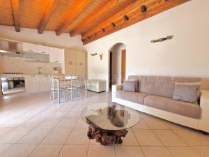 a living room with a couch and a table at Villetta Flora with pool and private parking in Costa Paradiso