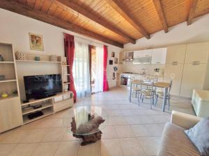 a living room with a couch and a tv and a table at Villetta Flora with pool and private parking in Costa Paradiso +43 photos
