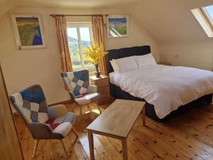 a bedroom with a bed and a table and chairs at Villa Daffodil - Sleeps 2 & Stunning Seaside Views in Cahersiveen
