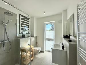 a bathroom with a sink and a toilet and a shower at Salt & Sand Wohnung Sun in Haffkrug