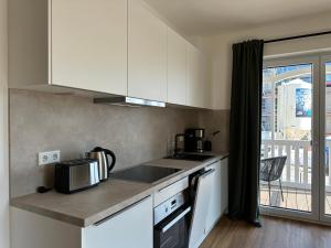 a kitchen with a sink and a counter with a microwave at Salt & Sand Wohnung Sun in Haffkrug +15 photos