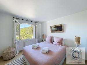 une chambre avec un grand lit avec une fenêtre dans l'établissement Villa SHALIMAR vue mer et piscine chauffée, à La Croix-Valmer