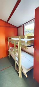 Etagenbett in einem kleinen Zimmer mit Fenster in der Unterkunft Camping 3 étoiles - Parc aquatique - ccbbeec in Beaumont-du-Périgord