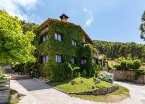 a house covered in ivy with a garden in front at Jardín del Mar in Mougás