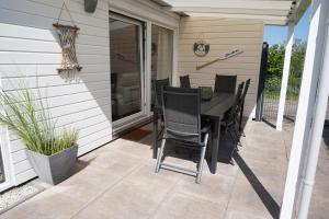 a patio with a table and chairs on a porch at Kustverhuur, Park Schoneveld, Zeester 49 in Breskens
