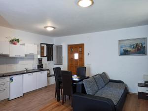 a kitchen and a living room with a couch and a table at Plitvice Studio Apartments in Rudanovac