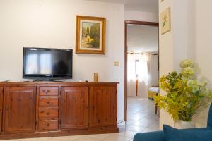 a living room with a television on a wooden cabinet at La Caletta 5 in La Caletta
