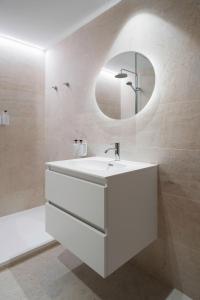 a white bathroom with a sink and a mirror at Apartamentos Ca Gracia 1 Estándar in Bocairent