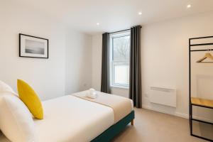 a bedroom with a white bed and a window at 2 Bedroom Apartment Near City Centre, Uni & Parks! in Cardiff