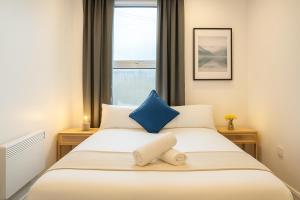 a bedroom with a bed with a blue pillow on it at 2 Bedroom Apartment Near City Centre, Uni & Parks! in Cardiff