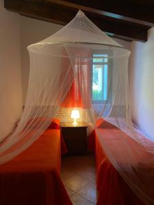 a bedroom with two beds with a mosquito net at Relax e Natura a Carini in Carini +2 photos