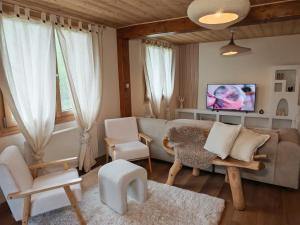 ein Wohnzimmer mit einer Couch und einem Tisch und Stühlen in der Unterkunft Chalet Toscane avec bain nordique in La Bresse