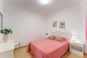 a bedroom with a bed with a pink blanket at Spacious apartment with the private terrace in Arona