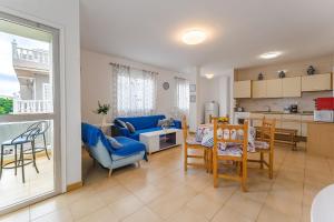 a kitchen and a living room with a table and chairs at Spacious apartment with the private terrace in Arona
