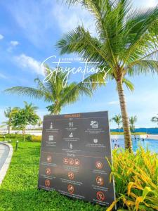 a sign in front of a beach with palm trees at Modern Bali of Azure North in San Fernando +4 photos