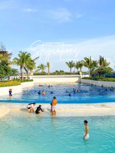 a group of people in the water at a swimming pool at Modern Bali of Azure North in San Fernando