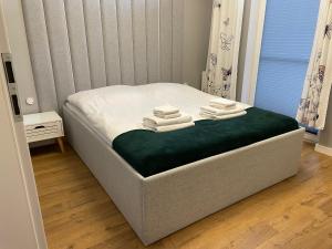 a bed with towels on it in a bedroom at Apartament Drugi Dom Sztutowo Baltic Twins in Sztutowo
