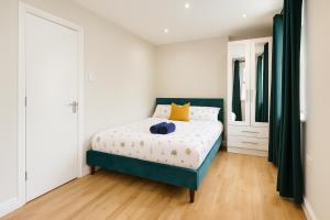 a bedroom with a bed with white walls and green curtains at One Bedroom Apartment In City Centre in Cardiff +1 photo