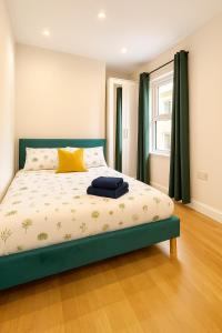 a bedroom with a bed with a green frame and a window at One Bedroom Apartment In City Centre in Cardiff