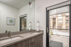 a bathroom with two sinks and a large window at Beaverhead Condo - 5 Slalom #301 in Big Sky +33 photos