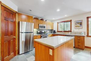 a kitchen with wooden cabinets and a stainless steel refrigerator at Peace and Pines at Upper Ward Creek in Tahoe City