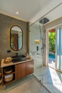 une salle de bain avec un lavabo et un miroir dans l'établissement Romeo Lane The Boutique Resort, à Assagao