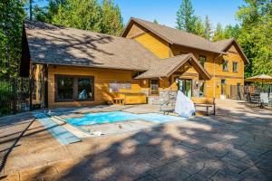 a home with a pool in front of a house at Whitefish Escape in Whitefish