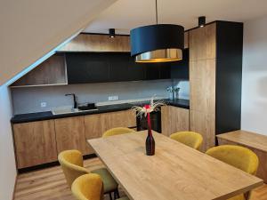 een eetkamer met een houten tafel en gele stoelen bij Apartment Tanja 3 Bedroom, Mountain View & Family Stay in Golnik +44 foto's