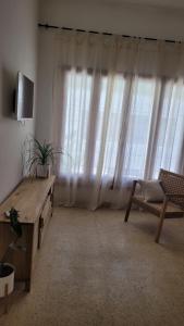 a living room with a large window with curtains at Departamento para dos personas, zona Basílica de Lujan in Luján