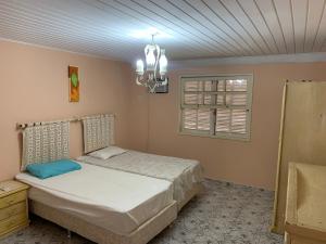 a bedroom with a bed and a chandelier at Toca da Tartaruga 31, PISCINA PRIVATIVA EXCLUSIVA in Armacao dos Buzios +25 photos