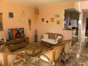 a living room with a tv and a couch and chairs at Toca da Tartaruga 31, PISCINA PRIVATIVA EXCLUSIVA in Armacao dos Buzios