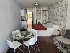 een slaapkamer met een bed en een glazen tafel en stoelen bij Central Charco in Puerto de la Cruz